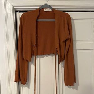 Cropped light sweater with tie in front